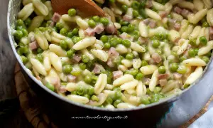 Pasta con prosciutto cotto e piselli, un piatto cremoso e saporito, pronto per essere gustato.