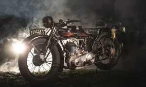 Stary motocykl z widocznym silnikiem i tablicą rejestracyjną. W tle mgła i światło, sugerujące tajemniczą atmosferę, która podkreśla jego historię i różne pojemności motocykli.