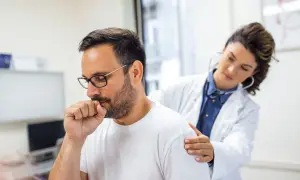 Médica examina a un hombre con tos, uno de los bronquitis síntomas.