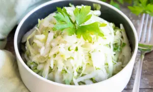 Frischer Krautsalat, perfekt zum krautsalat selber machen. Mit Petersilie garniert, serviert in einer Schüssel.