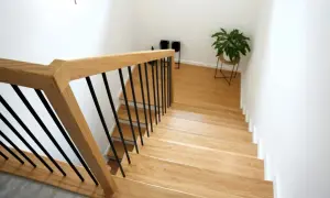 Nowe schody drewniane z czarnymi balustradami. Zobacz, jak zrobić schody drewniane, by nadać domowi ciepły i nowoczesny wygląd.