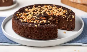 Torta di pane al cioccolato, soffice e ricca, guarnita con pinoli tostati. Un dolce goloso che profuma di casa.