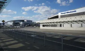 Nowoczesny budynek portu lotniczego im. Henryka Wieniawskiego, z charakterystycznym zadaszeniem i parkingiem.