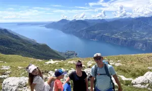 Rodzina z psem cieszy się widokiem na jezioro Garda z Monte Baldo.