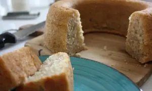 En saftig banankaka i sockerkaksform, uppskuren och serverad på en turkos tallrik.