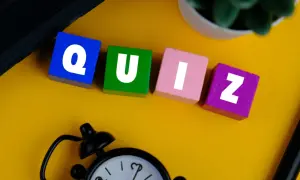 Kolorowe klocki z literami tworzą słowo QUIZ. Zegar i roślina sugerują, że czas sprawdzić swoją znajomość!