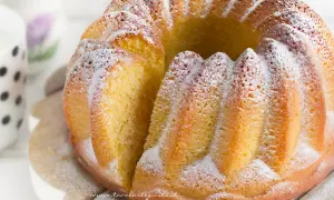 Un soffice ciambellone allo yogurt, cosparso di zucchero a velo, pronto per essere gustato.