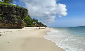 Piękna plaża Diani z białym piaskiem, turkusową wodą i skalistym klifem. Idealne miejsce na relaks.
