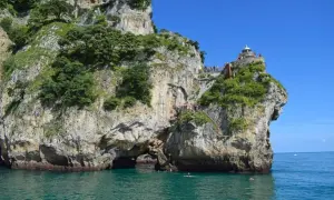 Escaleras y faros en Cantabria, con gente disfrutando del mar y la costa rocosa.