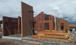 Construcción de casas entramado ligero con paneles prefabricados de madera. Andamios y materiales listos para seguir levantando las estructuras.