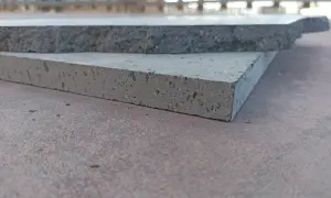 Due piastrelle in pietra lavica, una più chiara e porosa, l'altra più scura e compatta, mostrano la loro texture unica.