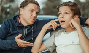 Padre parla con figlio adolescente, cercando di capire cosa fare quando i figli grandi litigano.