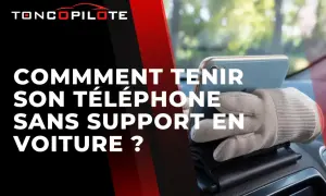 Astuce pour comment faire tenir son téléphone en voiture sans support : une main gantée maintient le téléphone sur le tableau de bord.
