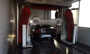 Samochód wjeżdża do myjni automatycznej. Czas dowiedzieć się, jak umyć samochód, by lśnił czystością!