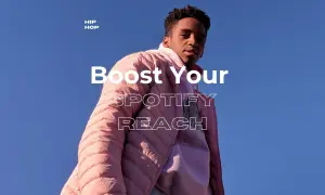 A young man in a pink puffer jacket looks up, text reads "Boost Your SPOTIFY REACH." Discover curated playlists to amplify your music.