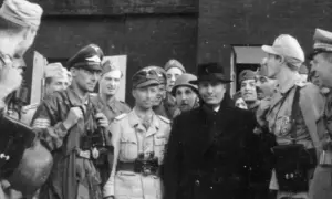 Grupp av män, varav en med hatt och rock, möjligen Otto Skorzeny, omgiven av militärer i uniform.