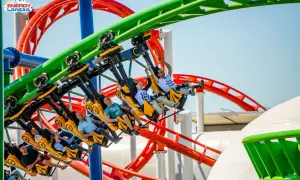 Ludzie krzyczą z radości na żółtych wagonikach rmf dragon roller coaster w Energylandii.