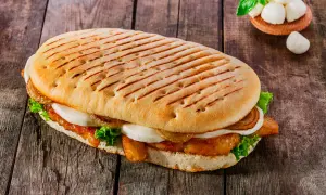 Ein gegrilltes Panini mit Hähnchen, Mozzarella, Salat und karamellisierten Zwiebeln. Ein leckeres panini rezept für jeden Tag.