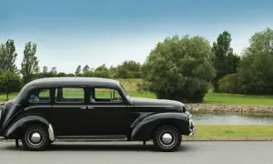 En svart, klassisk Volvo står parkerad vid en sjö. Denna gamla skönhet är en riktig sugga bil, perfekt för en tidlös resa.