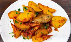 Pommes de terre rôties, coupées en quartiers et parsemées de persil frais. Une recette simple et savoureuse pour un accompagnement parfait.