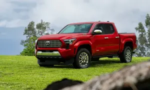 Czerwona Toyota Tacoma na zielonej trawie, gotowa na przygodę.