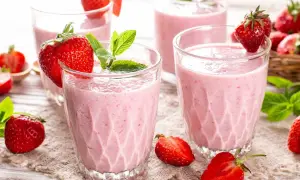 Batidos de fresa en vasos con fresas frescas y hojas de menta.