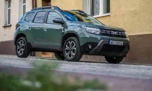 Zielony Dacia Duster na brukowanej ulicy. Wiele pozytywnych dacia duster opinie potwierdza jego wszechstronność.