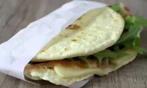 Leckeres Piadina Rezept: Fladenbrot gefüllt mit Schinken, Käse und Rucola, perfekt für unterwegs.