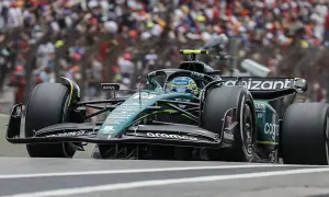 Coche de Fórmula 1 verde y negro en pista, con público al fondo. El piloto, con casco azul, busca ser libres 2.