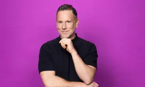 Peter Jihde, med en tankfull blick och handen mot hakan, poserar framför en lila bakgrund.