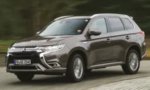 Brązowy Mitsubishi Outlander w ruchu. Wiele osób szuka mitsubishi outlander opinie, ten SUV jest świetnym wyborem.