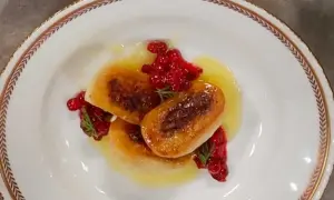 Tre gyllene kroppkakor serveras med lingon och en ljus sås. Ett vackert recept på kroppkakor!