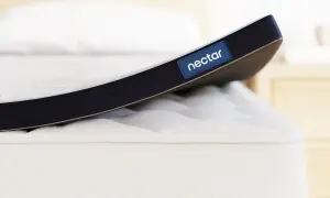A Nectar mattress topper is shown. While toppers can improve comfort, it's worth considering if a mattress topper can cause back pain if it's too soft or firm for your needs.