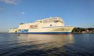 Duży biały prom TT-Line "Peter Pan" płynie po wodzie przy słonecznej pogodzie.