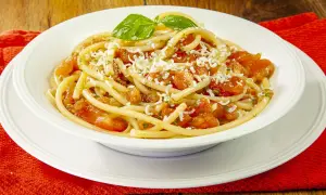 Un piatto invitante di pasta alla carrettiera, con pomodoro fresco, basilico e formaggio grattugiato.