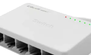 Biały, kompaktowy switch sieciowy z pięcioma portami RJ45 i diodami sygnalizującymi aktywność.