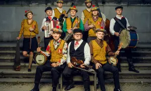 Warszawskie combo taneczne w szkockich beretach gra na instrumentach: banjo, skrzypcach, akordeonie, saksofonie, kontrabasie i bębnach.