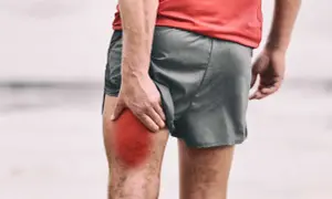Un corridore si tiene la coscia, evidenziata in rosso, a causa di gambe intorpidite.