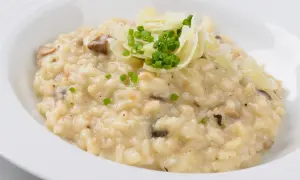 Cremiges Pilzrisotto, garniert mit Parmesan und Schnittlauch. Perfekt zubereitet mit dem besten Risottoreis für ein authentisches Geschmackserlebnis.