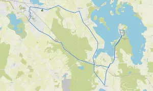 Mapa turystyczna z zaznaczoną trasą wokół miasta nad jeziorem Skiertąg. Widoczne jezioro, lasy i zabudowania.