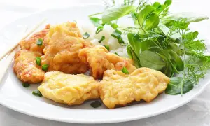 Chrupiący kurczak w kokosie, podany z ryżem i świeżymi ziołami. Idealny na lekki posiłek.