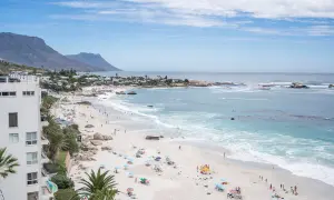 Sonniger Strand in Kapstadt mit vielen Menschen, die entspannen. Die Frage "ist Kapstadt sicher?" scheint hier positiv beantwortet.