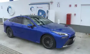 Niebieska Toyota Mirai na stacji tankowania wodoru. Sprawdź aktualną toyota mirai cena i ekologiczną przyszłość motoryzacji.