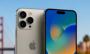 Nowy iPhone z potrójnym aparatem na tle Mostu Golden Gate i palmy.