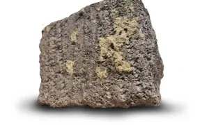En bit porös, mörkgrå sten med ljusare gula partier. Så här ser blåbetong ut, en lätt och isolerande sten.