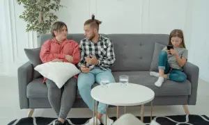 Rodzice rozmawiają z psychologiem rodzinnym, podczas gdy ich córka zajmuje się telefonem.