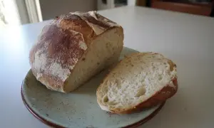 Nybakad ciabatta, perfekt för ditt nästa ciabatta recept. En bit är uppskuren och visar det luftiga inkråmet.