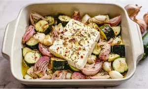 Gebackene Zucchini mit Feta, roten Zwiebeln und Knoblauch in einer Auflaufform, bereit für den Ofen.