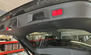 Två röda knappar, en med stopp-symbol, sitter på insidan av bakluckan. En liten röd lampa lyser. Problem med elektrisk baklucka?