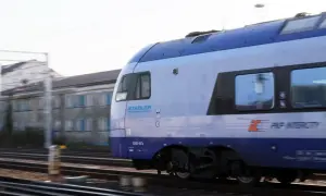 Pociąg PKP Intercity Stadler ED160-007a mija budynek w ruchu. Może to być podróż z Chełma do Krakowa.